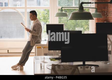 Männliche executive Sitzen am Tisch Lesen von Dokumenten Stockfoto
