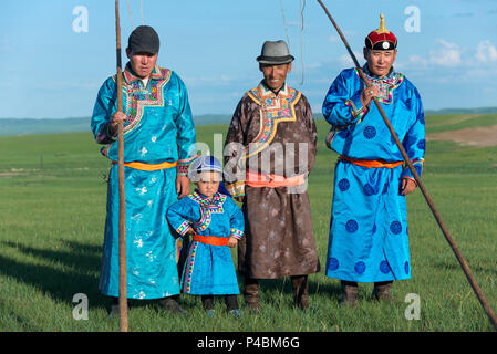 Tragen traditionelle mongolische Kleid, ein kleiner Junge steht pridefully mit älteren Familienmitgliedern, Xilinhot, der Inneren Mongolei, China Stockfoto