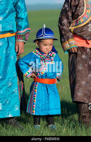 Tragen traditionelle mongolische Kleid, ein kleiner Junge steht pridefully mit älteren Familienmitgliedern, Xilinhot, der Inneren Mongolei, China Stockfoto