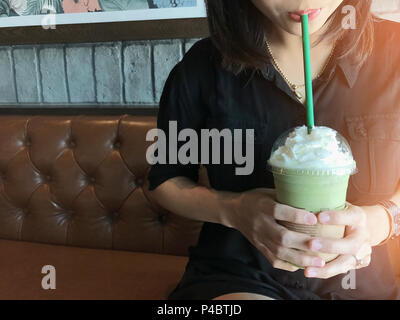 Asian Business Frau trinken grünen Tee frappe, gerade im Cafe am Morgen entspannen. Stockfoto