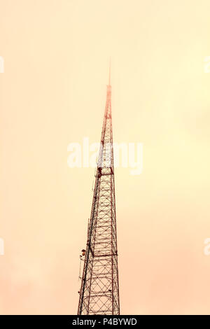 Low-angle vertikale Ansicht von KCPTV Fernsehturm gegen orange sky in einer nebligen Tag bei Sonnenuntergang Stockfoto