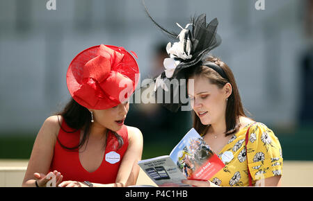 Weibliche racegoers lesen Sie das Programm während der Tag drei des Royal Ascot Hotel in Ascot Pferderennbahn. Stockfoto