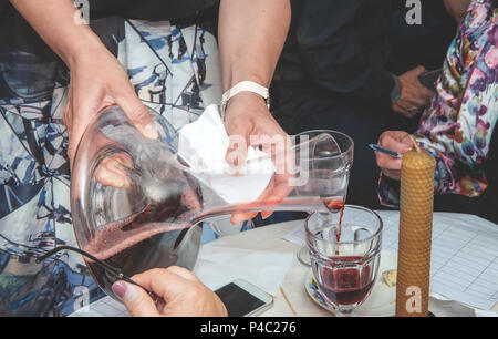 Der Sommelier gießt Wein in ein Glas aus einer Schüssel. Belüftung von Rotwein. Dekanter. Stockfoto