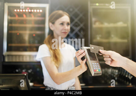 Nahaufnahme von Hand mit Kreditkarte swiping Machine zu bezahlen. Stockfoto