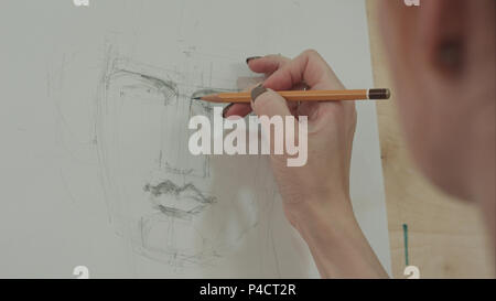 Konzentrierten Künstlerin Malerei klassischen Mann Portrait mit Bleistift Stockfoto