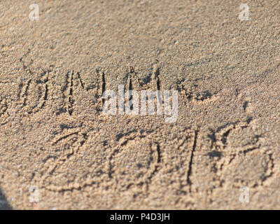Handgeschriebene Nachricht auf dem Sand an einem Strand in der Nähe der Wasser Stockfoto