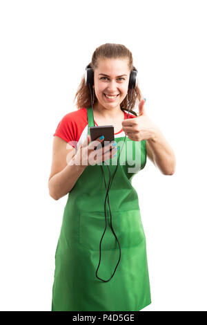 Weibliche Supermarkt oder SB-Warenhaus Mitarbeiter Musik hören und wie Geste als Daumen nach oben song Konzept auf weißem Hintergrund Stockfoto