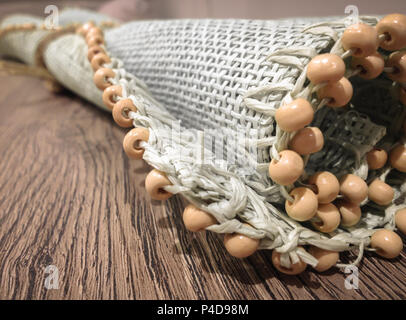 Kleine Walze wicker Mat auf vintage Tabelle. Ausstattung Zubehör für Zuhause. Close-up. Stockfoto