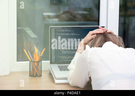 Frau freier Programmierer, die von zu Hause aus arbeiten. website Code auf dem Bildschirm Stockfoto