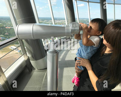 Asiatische Mutter und niedlichen Baby genießen Sie Ferngläser die Stadt im hohen Turm Hintergrund. Stockfoto