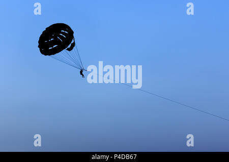 Silhouette parasail Kotflügel gezogen, auf blauen Himmel Hintergrund. Stockfoto