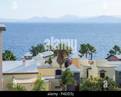 Blick auf Spanisch Dächer zum Meer und darüber hinaus auf einem klaren hellen Tag in Lanzarote Stockfoto