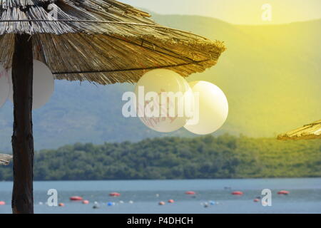Ballone hängend auf einer hölzernen Sonnenschirm am Strand Stockfoto