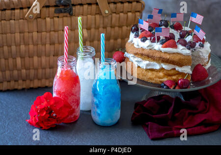 Frische Erdbeeren Angel Food Cake mit Blaubeeren, Erdbeeren, Kirschen und Sahne, und bunten Frozen Drinks mit oder ohne Alkohol. Holid Stockfoto