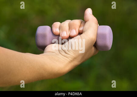 Hand Übungen mit Hantel auf Natur Hintergrund Stockfoto