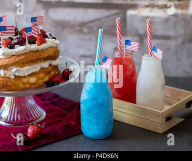 Rot, Weiß und Blau gefrorenen Getränke und patriotische Angel Food Cake mit Blaubeeren, Kirschen und Erdbeeren. Zufrieden Juli 4. Stockfoto