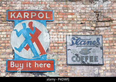 London, Großbritannien - 5. Juni 2017: alte Zinn Werbeschilder für Karpol und Stanes Kaffee, auf einer alten Red brick wall auf der South Bank, London. Stockfoto