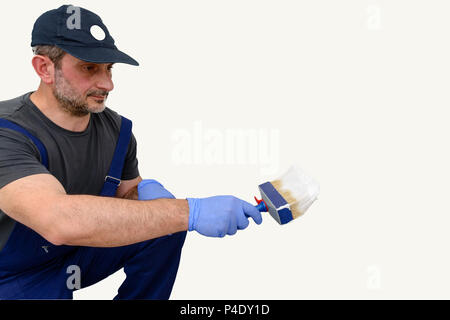 Der Maler mit einem weissen Pinsel. Weißer Hintergrund mit leeren Bereich. Detail der Bürste die weiße Farbstoff für die Arbeit des Malers vorbereitet ist. Stockfoto