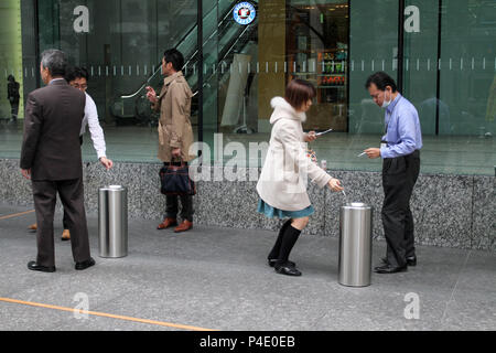 Japanische Leute rauchen Rauchen Zigaretten in einem speziellen Bereich auf der Straße von Tokio, Japan - Jan, 24, 2011. Stockfoto