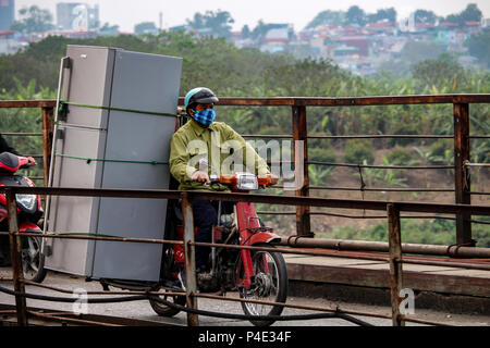 Hanoi, Vietnam - 15. März 2018: Vietnamesische mann Transport einen riesigen Kühlschrank auf seinem Motorrad Stockfoto