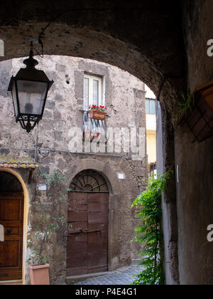 Kleine Gasse mit Bogen und hing Lamp Post, auf der Straße vor einem kleinen italienischen mittelalterliches Dorf Stockfoto