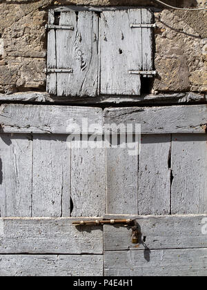 Alte Holztür mit Metall-Schraube, schließen ein Haus aus Stein Stockfoto
