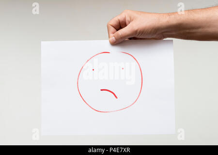 Ein Blatt Papier mit einem gezeichneten Gesicht angewidert Stockfoto