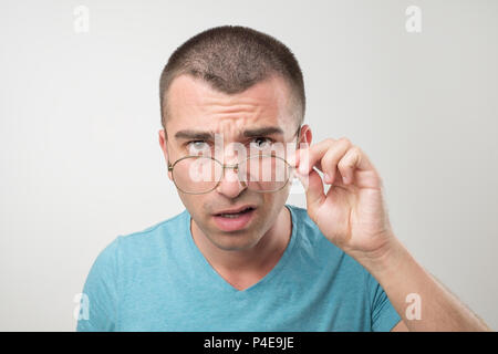 Wow facial emotion Konzept. Junger Mann mit geöffnetem Mund Brille berühren überrascht. Er ist überrascht, etwas zu bemerken Stockfoto