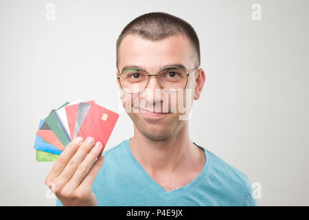 Close up Portrait des jungen Mannes in Gläsern halten eine Menge gredit Karten. Konzept der cash Finance oder sein Reich Stockfoto
