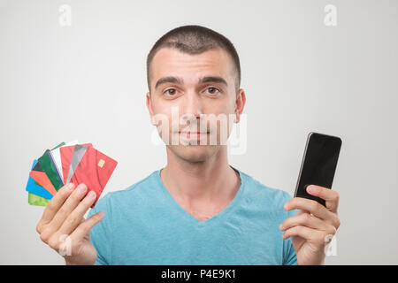 Close up Portrait des jungen Mannes in Gläsern halten eine Menge gredit Karten und Telefon. Konzept der cash Finance oder sein Reich Stockfoto