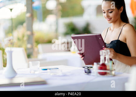 Schöne Frau Bestellungen aus dem Menü Stockfoto