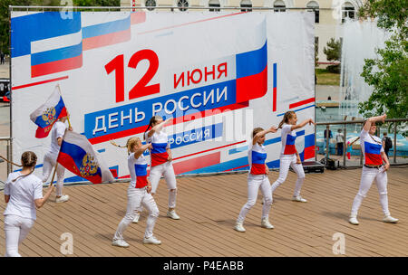 Russland, Wladiwostok, 06/12/2018. Childs in bunten Garnituren als Russische Fahne gemalt durchführen Song auf der Bühne. Feier der jährlichen Russland Tag auf Juni Stockfoto