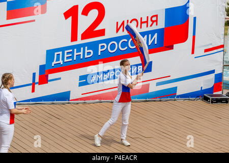 Russland, Wladiwostok, 06/12/2018. Childs in bunten Garnituren als Russische Fahne gemalt durchführen Song auf der Bühne. Feier der jährlichen Russland Tag auf Juni Stockfoto