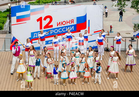 Russland, Wladiwostok, 06/12/2018. Childs in bunten Garnituren als Russische Fahne gemalt durchführen Song auf der Bühne. Feier der jährlichen Russland Tag auf Juni Stockfoto