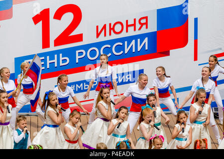 Russland, Wladiwostok, 06/12/2018. Childs in bunten Garnituren als Russische Fahne gemalt durchführen Song auf der Bühne. Feier der jährlichen Russland Tag auf Juni Stockfoto