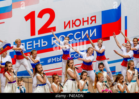 Russland, Wladiwostok, 06/12/2018. Childs in bunten Garnituren als Russische Fahne gemalt durchführen Song auf der Bühne. Feier der jährlichen Russland Tag auf Juni Stockfoto