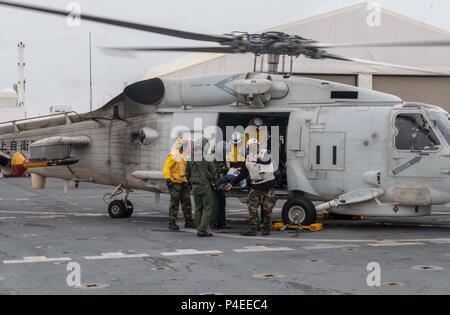 180617-N-RM 689-0119 Tokyo, Japan (17. Juni 2018) Segler zugeordnet zu militärischen Sealift Command Hospital Ship USNS Mercy (T-AH 19) für Pazifische Partnerschaft 2018 (PP18) und japanische Maritime Verteidigung-kraft (JMSDF) ein mock Patienten von einem SH-60K Sea Hawk Hubschrauber zum JMSDF während eines bilateralen Medical Training Team Bohrer zwischen Barmherzigkeit und JMSDF Personal verbunden. USNS Mercy macht port Besuche in Yokosuka und Tokio Beziehungen zwischen U.S. Navy Segler und japanische Bürger durch kulturellen Austausch und bilateralen Training zu fördern. (U.S. Marine Foto von Massenkommunikation Speci Stockfoto