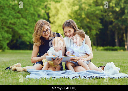 Eine Familie ist ein Buch auf das Gras. Stockfoto