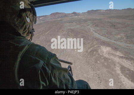 Sgt. Reyes Macedo, einem Hubschrauber Crew Chief mit Marine Light Attack Helicopter Squadron 775, Marine Flugzeuge Gruppe 41, 4 Marine Flugzeugflügel, erwirbt ein Ziel und Durchführung eine enge Luftunterstützung Mission, während integrierte Ausbildung Übung 4-18 bei Marine Corps Air Ground Combat Center Twentynine Palms, Calif., 18. Juni 2018. HMLA-775, auch bekannt als "kojoten" zur Verfügung, sofern Air Combat element Unterstützung für Marine Air Ground Task Force 23 während ITX 4-18. (U.S. Marine Corps Foto von Lance Cpl. Samantha Schwoch/freigegeben) Stockfoto