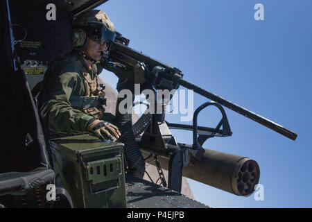 Sgt. Reyes Macedo, einem Hubschrauber Crew Chief mit Marine Light Attack Helicopter Squadron 775, Marine Flugzeuge Gruppe 41, 4 Marine Flugzeugflügel, bereitet die Marines, die integrierte Ausbildung Übung 4-18 bei Marine Corps Air Ground Combat Center Twentynine Palms, Calif., 18. Juni 2018 Close Air Support zu liefern. HMLA-775, auch bekannt als "kojoten" zur Verfügung, sofern Air Combat element Unterstützung für Marine Air Ground Task Force 23 während ITX 4-18. (U.S. Marine Corps Foto von Lance Cpl. Samantha Schwoch/freigegeben) Stockfoto