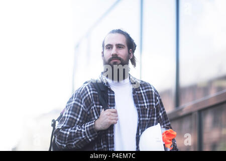 Menschen gehen auf die Straße mit einem Helm und Rucksack Stockfoto