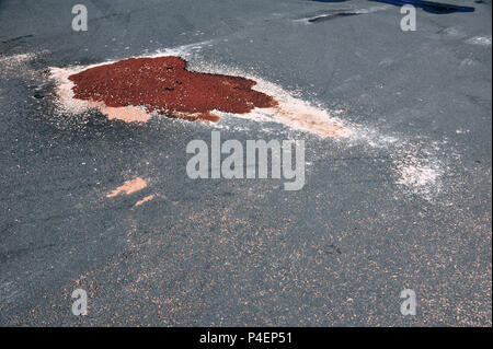Großen Ölteppich auf der Straße bei woodchippings bis seine gereinigt werden, abgedeckt Stockfoto