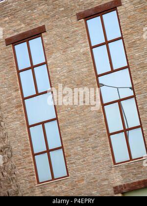 Lampenpfosten spiegelten sich an den Fenstern eines Gebäudes wider. Stockfoto