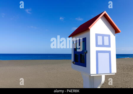 Ein miniaturmodell eines Hauses mit einem dunklen vulkanischen Strand und einem blauen Himmel im Hintergrund Stockfoto