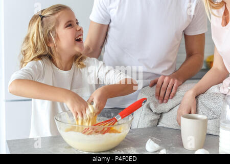 7/8 Schuß von Eltern lehren ihre Tochter glücklich zu kochen Stockfoto