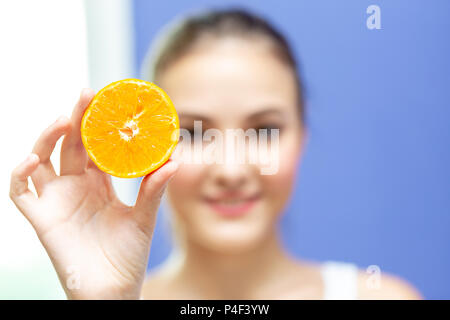 Junge Frau, Grapefruit oder Orange, und zeigen Sie auf Kamera. Gesundes Leben, Diät und Ernährung. Stockfoto