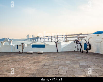 Metall Skulpturen auf der Haeundae promenade Förderung der Busan International Film Festival mit dem gwangan Bridge im Hintergrund bei Sonnenuntergang, Bu Stockfoto