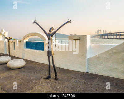 Metall Skulptur auf der Haeundae promenade Förderung der Busan International Film Festival mit dem gwangan Bridge im Hintergrund bei Sonnenuntergang, Bus Stockfoto