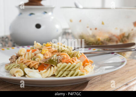 Bunte curly Makkaroni Salat mit Tomaten, surimi, Ei, Mais und Thunfisch Stockfoto