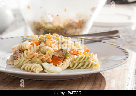 Bunte curly Makkaroni Salat mit Tomaten, surimi, Ei, Mais und Thunfisch Stockfoto